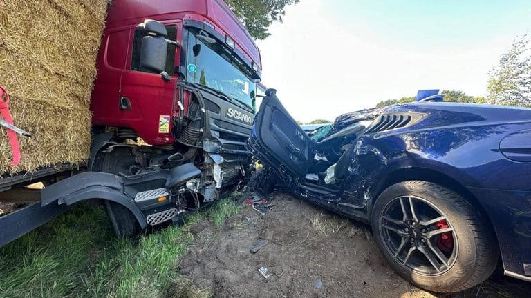 Rozbity samochód osobowy i ciężarówka po zderzeniu na drodze krajowej.