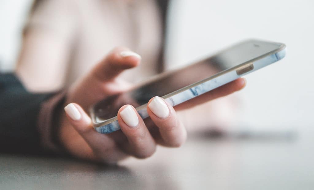 Dłoń trzymająca smartfon podczas korzystania z internetu mobilnego