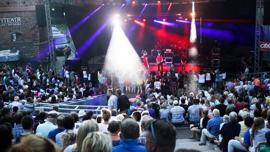 Publiczność na koncertowej scenie podczas festiwalu muzyki metalowej w centrum Olsztyna.