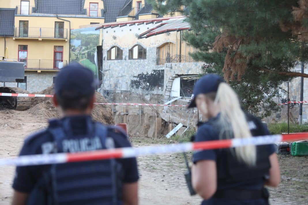 Policjanci na miejscu ewakuacji hotelu po uszkodzeniu ściany podczas prac budowlanych.