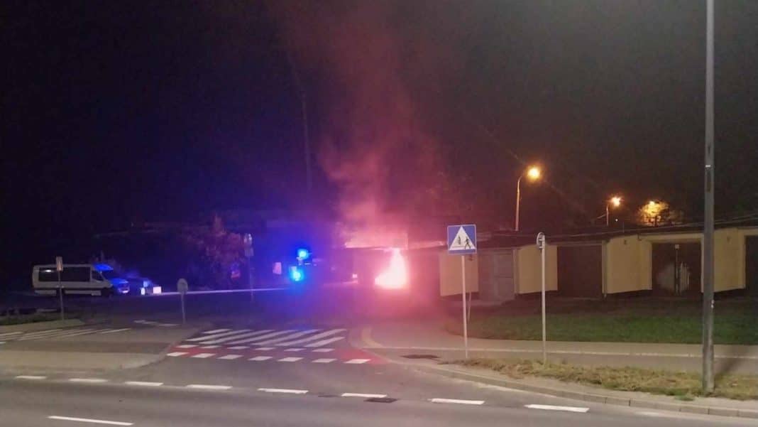 Pożar w pobliżu stadionu w Olsztynie, widoczne płomienie i dym w nocy.