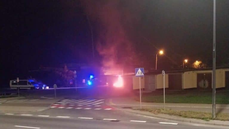 Pożar w pobliżu stadionu w Olsztynie, widoczne płomienie i dym w nocy.