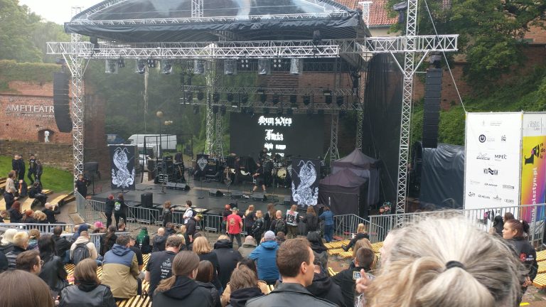Widok na scenę festiwalową w amfiteatrze, z tłumem widzów i nagłośnieniem.