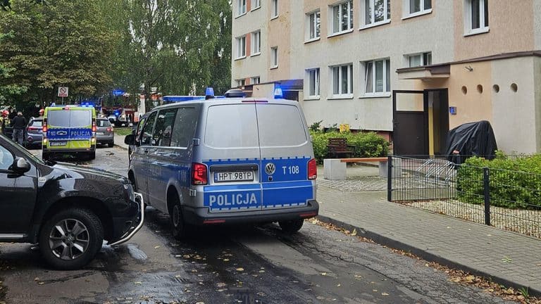 Na zdjęciu widoczne są pojazdy policyjne i straż pożarna przed blokiem mieszkalnym na ul. Kołobrzeskiej w Olsztynie.