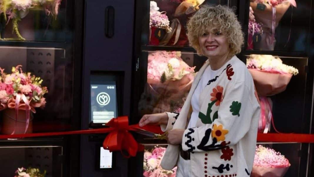 Kobieta korzysta z automatu do kwiatów w parku handlowym w Mrągowie.