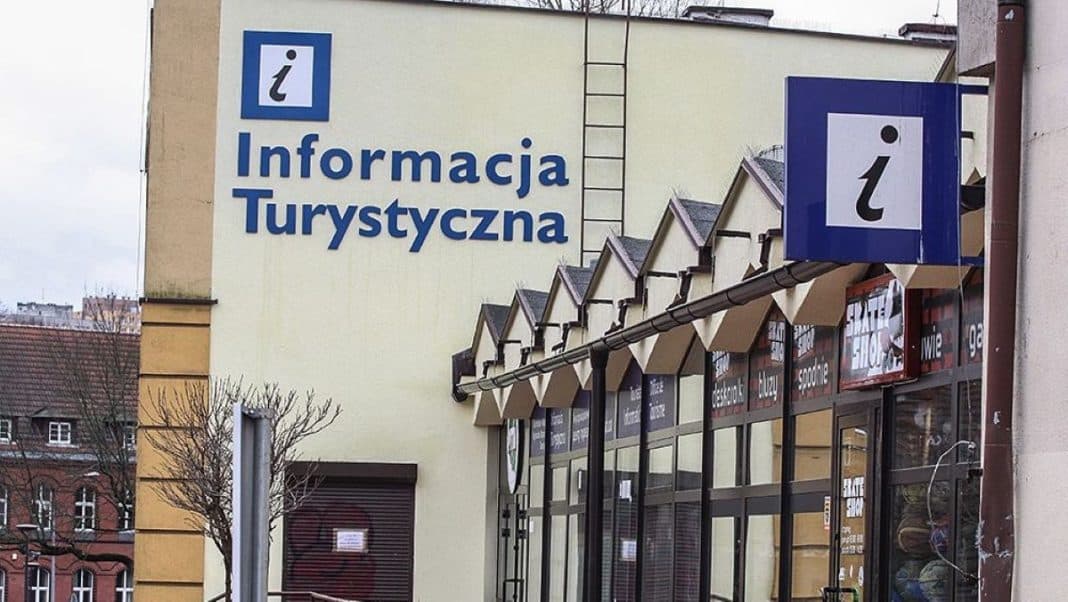 Budynek z dużym napisem 'Informacja Turystyczna' na ścianie, widok na wejście do punktu informacji.