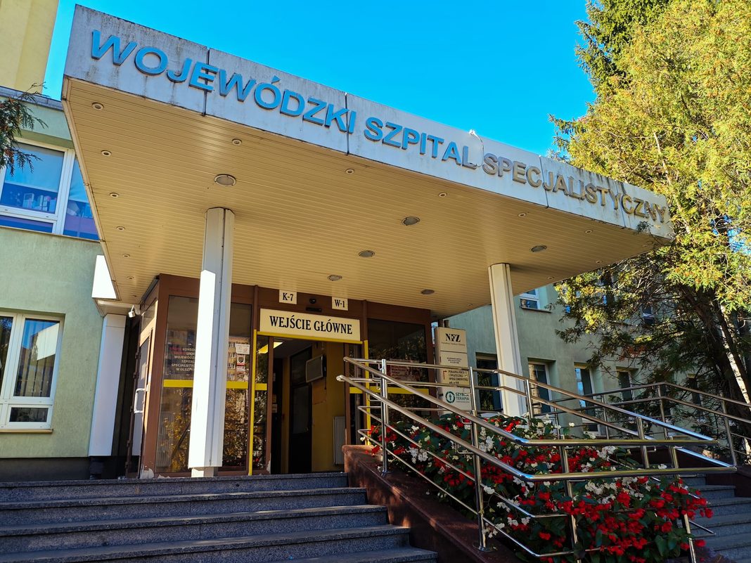 Plakaty z napisem 'Stop konsolidacji' na drzwiach szpitala w Olsztynie.