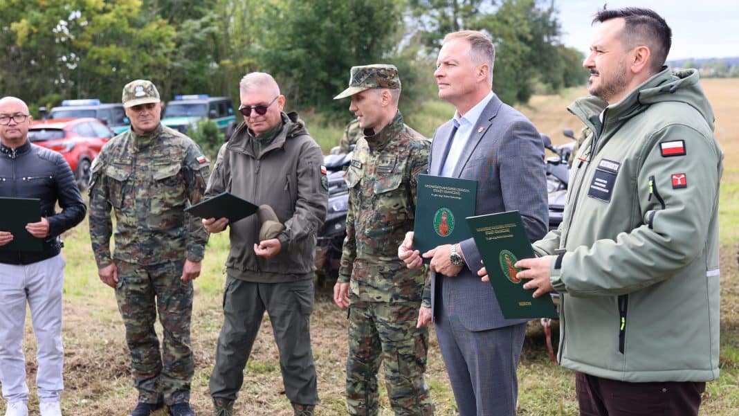 Grupa funkcjonariuszy Straży Granicznej podczas uroczystości przekazania nowego sprzętu na granicy z Rosją.