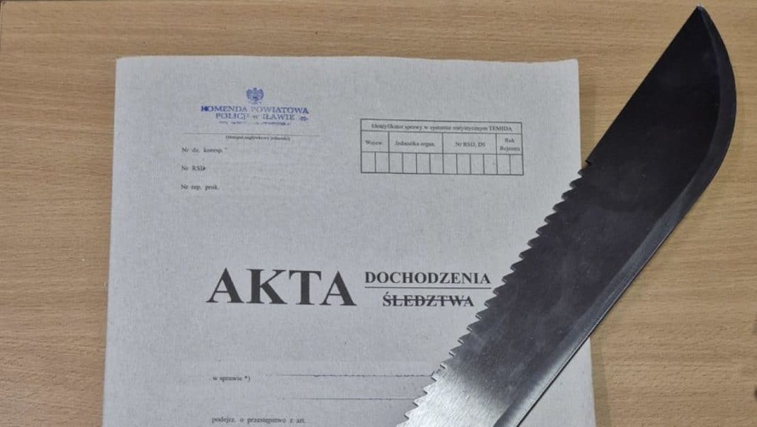 Dokument policyjny i maczeta na drewnianym stole, związane z sprawą przemocy domowej.