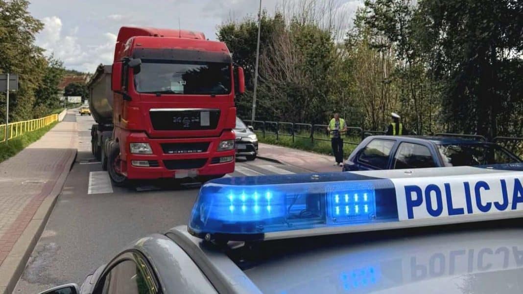 Ciężarówka zatrzymana na pasach, policja i świadkowie na miejscu zdarzenia.