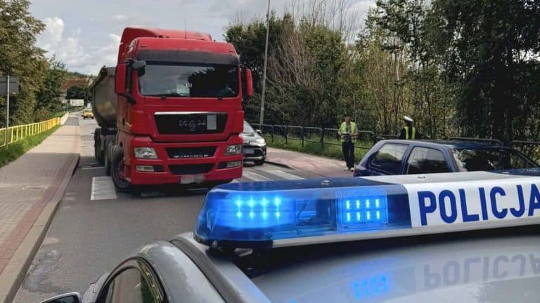 Ciężarówka zatrzymana na pasach, policja i świadkowie na miejscu zdarzenia.