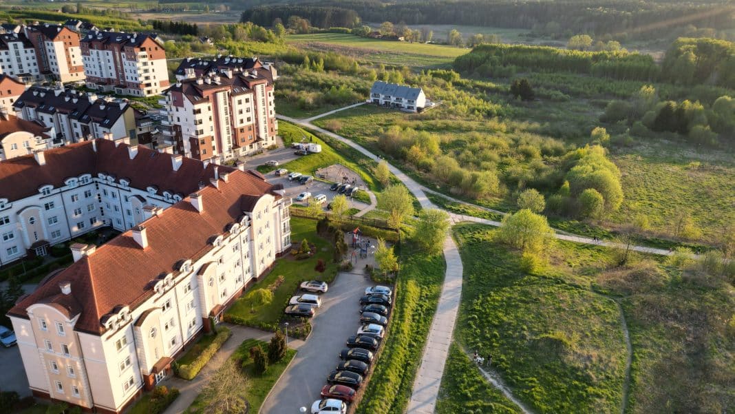 Widok na osiedle mieszkaniowe i tereny zielone w Olsztynie, wczesnym popołudniem.