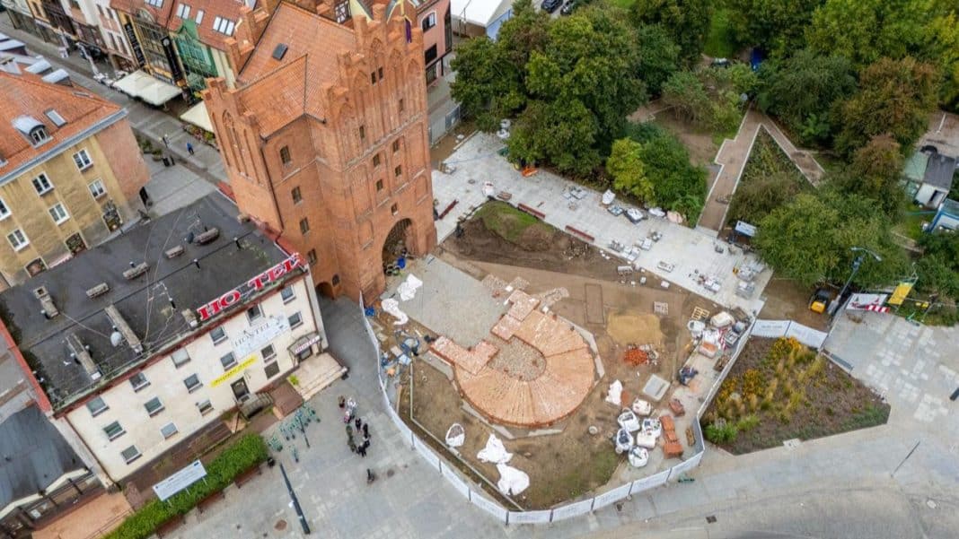 Widok na plac pod Wysoką Bramą w trakcie prac remontowych, z widocznymi wykopami i elementami budowy.