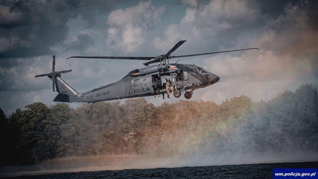 Policyjny śmigłowiec Black Hawk nad wodą podczas ćwiczeń służb na Warmii i Mazurach.