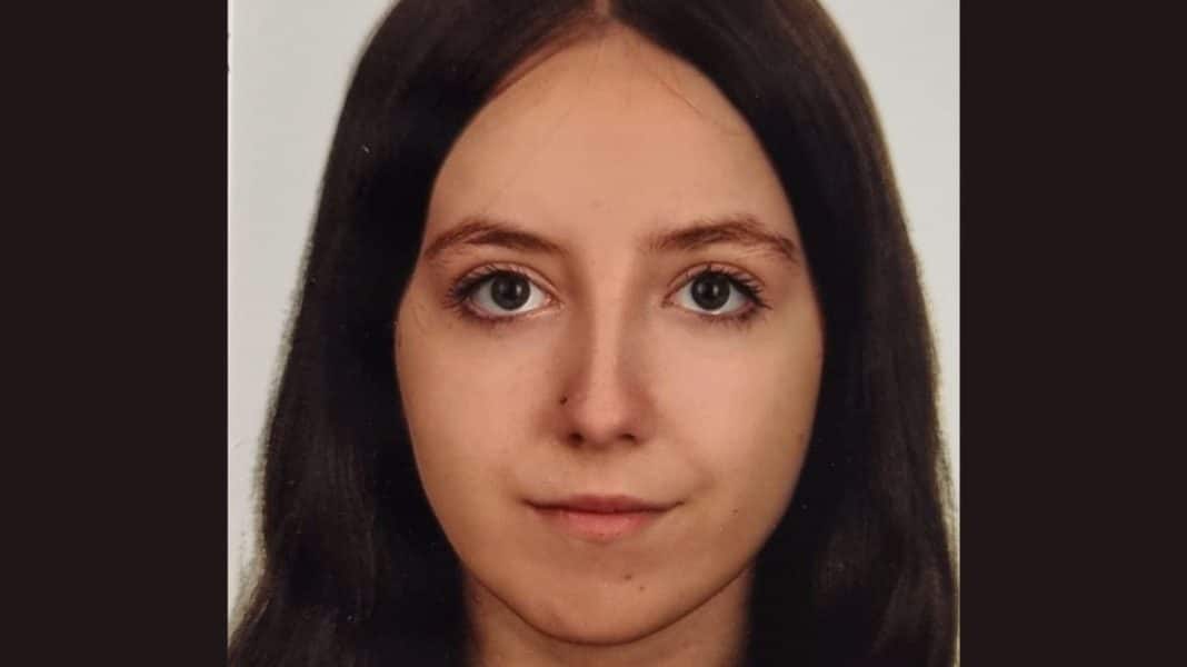 Portret młodej dziewczyny z długimi brązowymi włosami i jasną cerą.