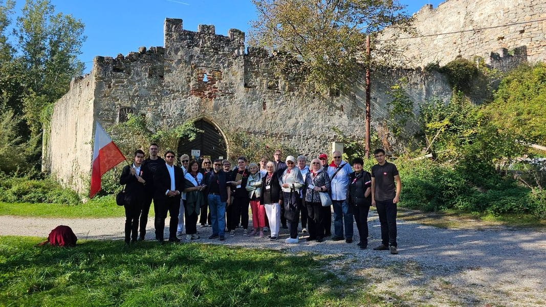 Grupa ludzi na tle ruin dawnego obozu koncentracyjnego w Górnej Austrii podczas Marszu Pamięci.