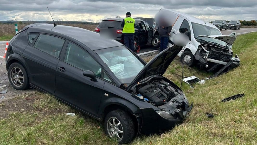 Wypadek na drodze krajowej z uszkodzonymi pojazdami i służbami ratunkowymi na miejscu.
