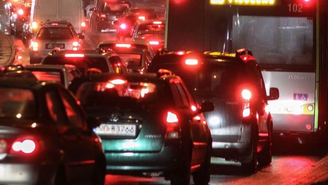 Korek samochodów na zatłoczonej ulicy w Olsztynie nocą, widoczne światła i zatory.