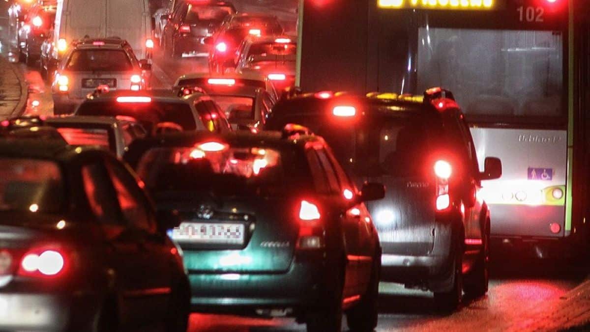 Korek samochodów na zatłoczonej ulicy w Olsztynie nocą, widoczne światła i zatory.