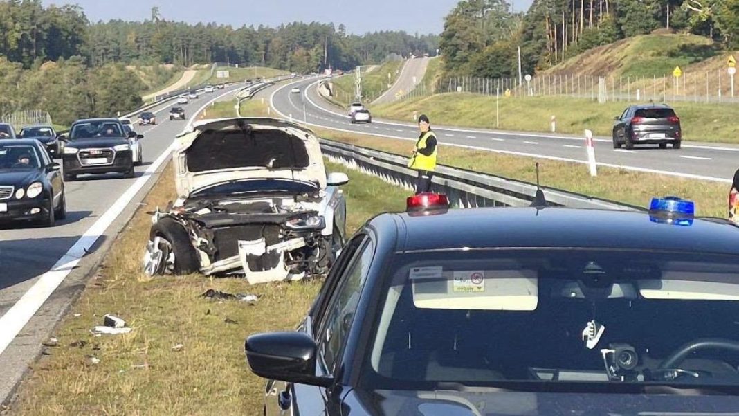 Zderzenie samochodu osobowego z ciężarówką na drodze S7, uszkodzony pojazd i policjant na miejscu.