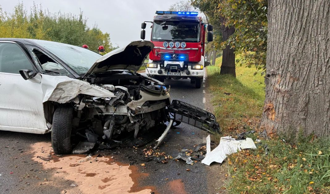 Rozbity samochód po wypadku na drodze, służby ratunkowe na miejscu zdarzenia.