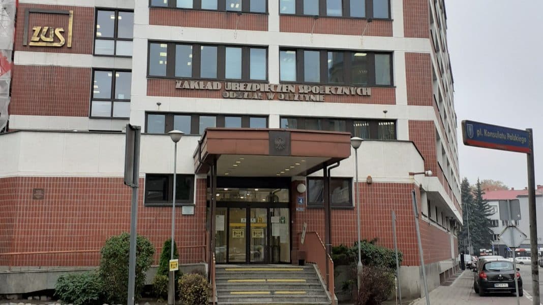 Budynek ZUS na tle szarego nieba, widoczny główny wejście i oznaczenia instytucji.