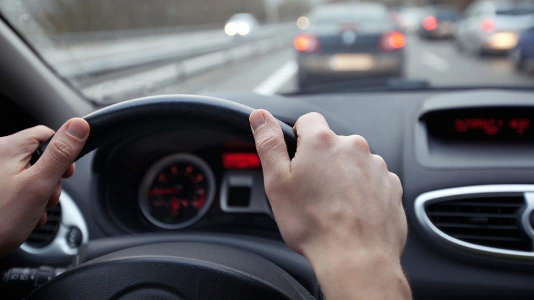 Widok z wnętrza samochodu na drogę krajową z innymi pojazdami w ruchu.