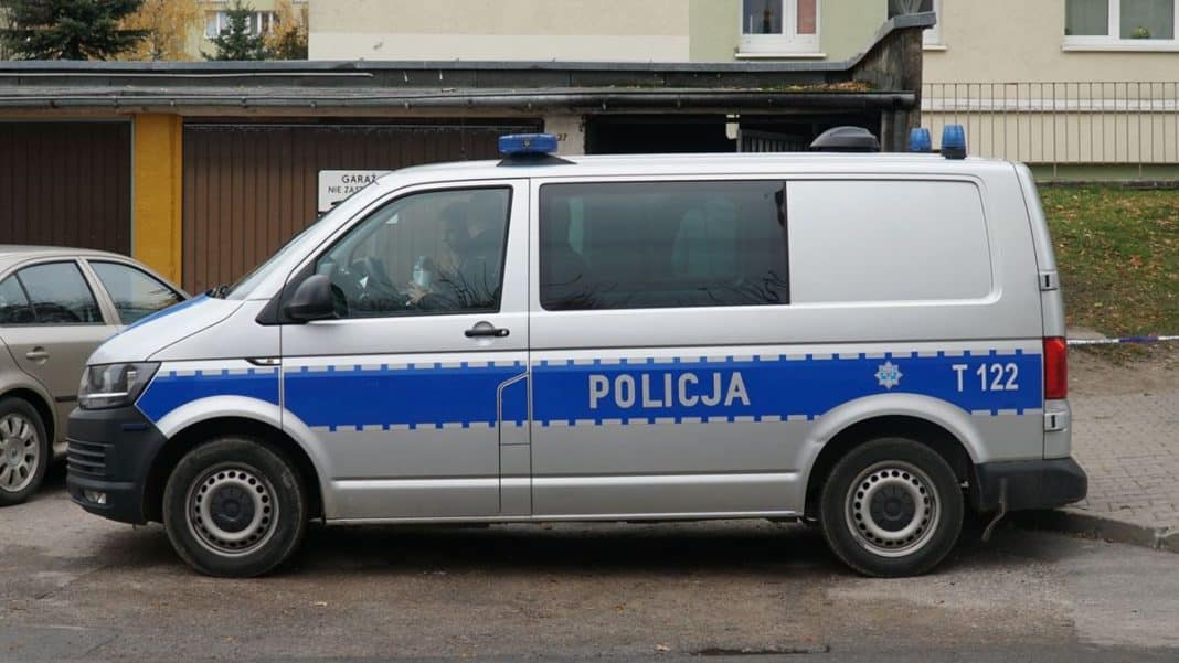 Policja na parkingu w Lidzbarku Warmińskim, widoczny radiowóz policyjny.