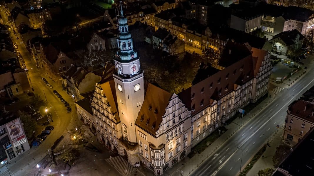 Olsztyński ratusz podświetlony na zielono w centrum miasta, widok z drona nocą.