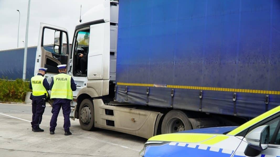 Policjanci przeprowadzają kontrolę na drodze ekspresowej S61 przy dużym ciężarowym pojeździe.